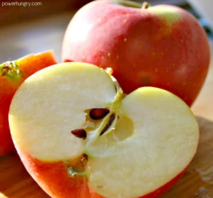tart sweet Gala apple , sliced in half on a cutting board