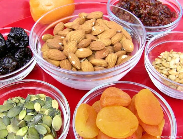 ingredients for fruit nut and seed bars on a red plate
