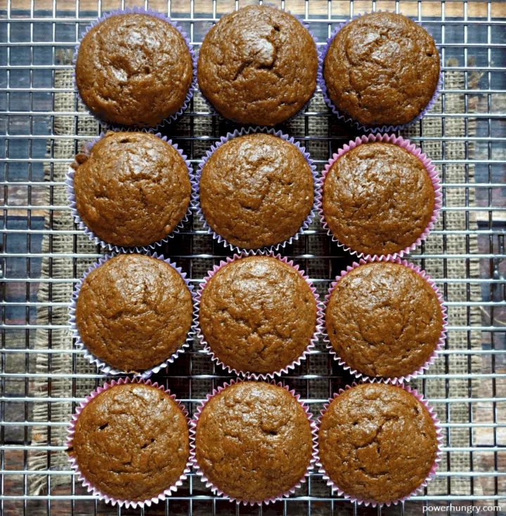 overhead shot of a dozen chickpea flour gingerbread muffins on a silver cooling rack.