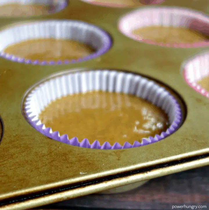 close up of muffin liners in a muffin tin, filled with chickpea flour muffin batter