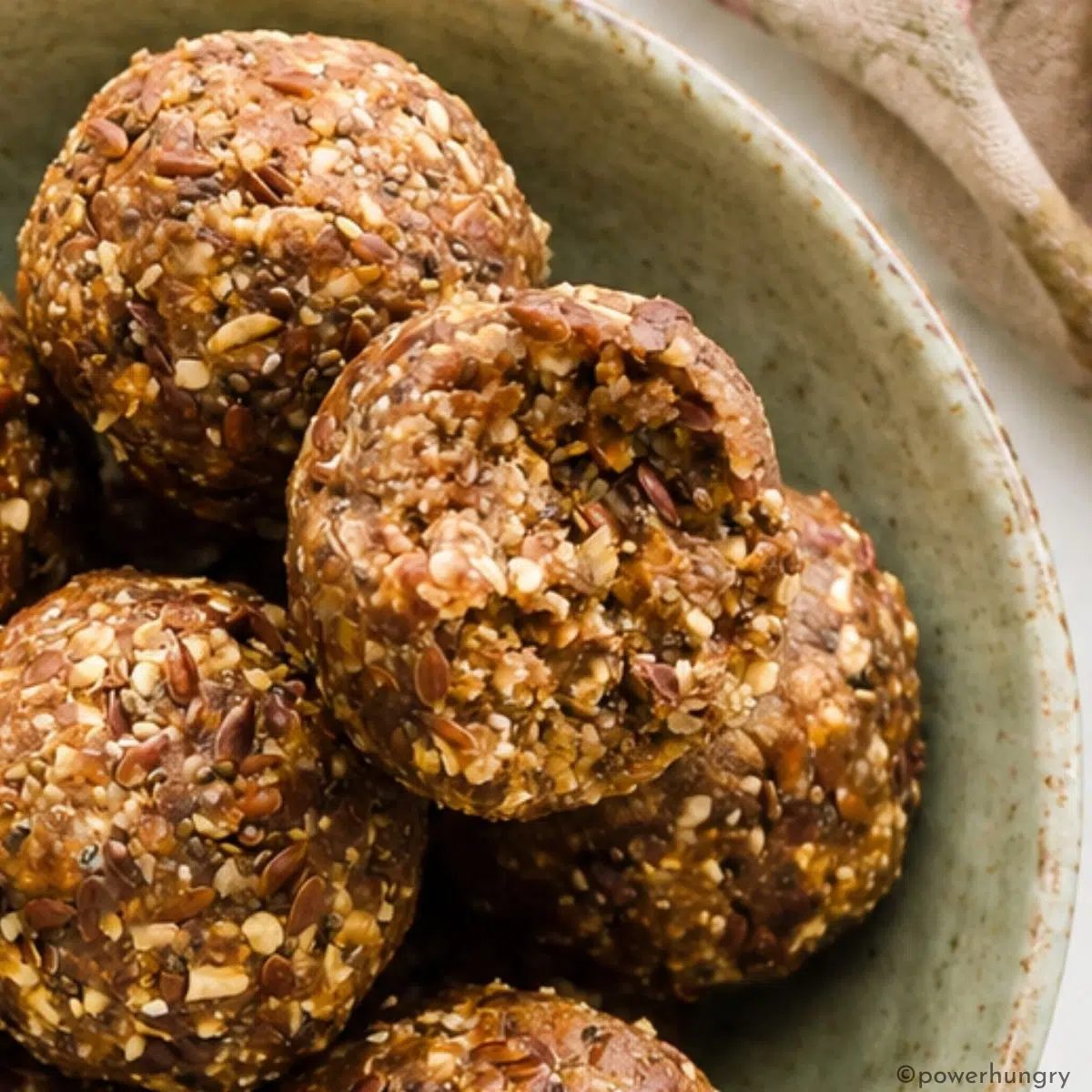 close up of gingerbread energy balls with a bite taken out of one to show the texture
