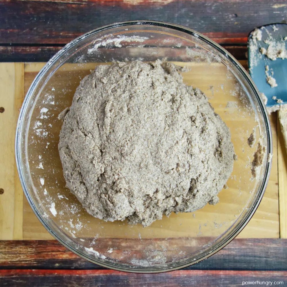 ball of buckwheat bread dough in a clear glass bowl