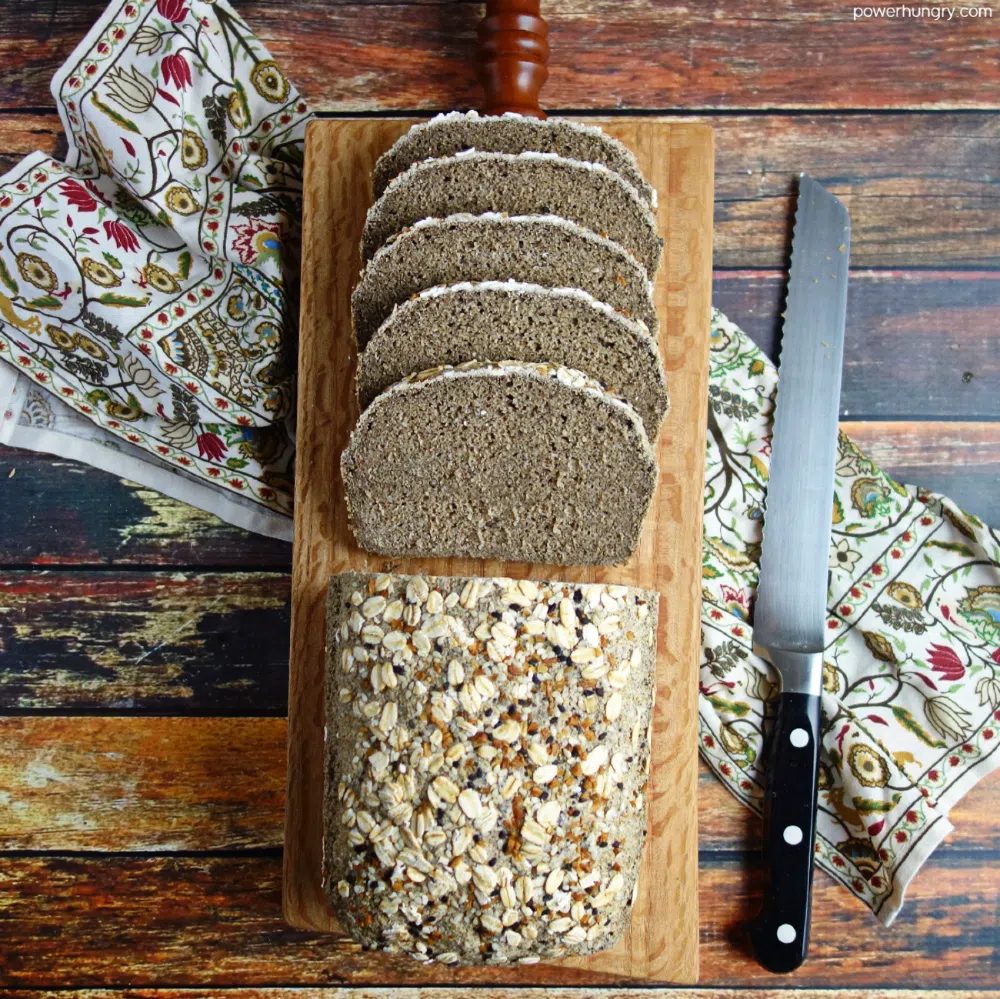overhead shot of vegan rice bread cut into slces, on a wood cutting board