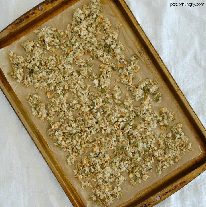 unbaked grain-free granola on a parchment paper-lined baking sheet