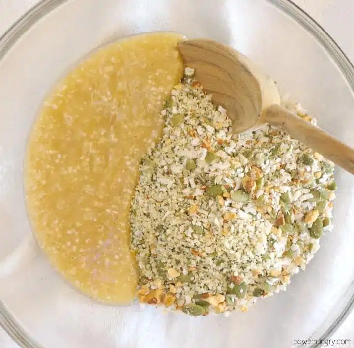 wet and dry ingredient for grain-free granola in a glass mixing bowl