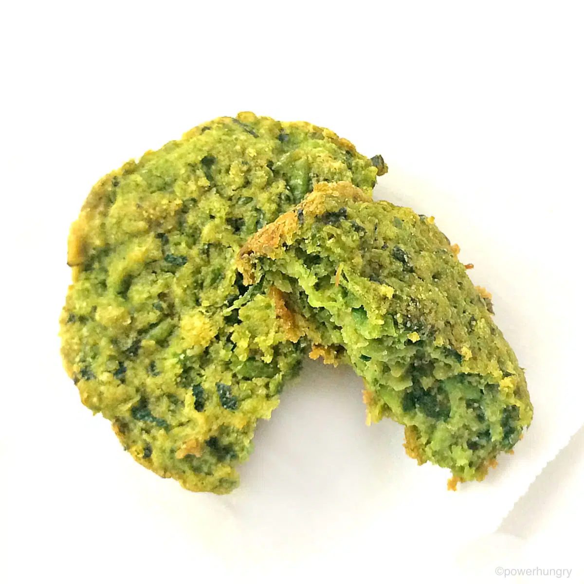overhead shot of two Supergreen baked falafel patties, one with a bite taken out
