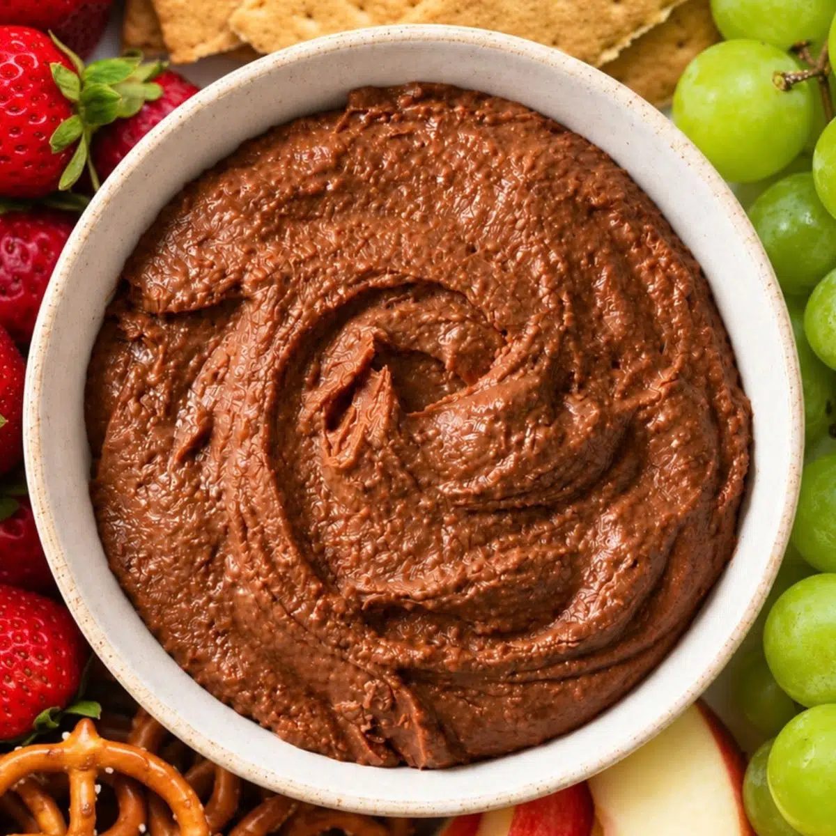 brownie batter hummus surrounded by fruit and pretzels