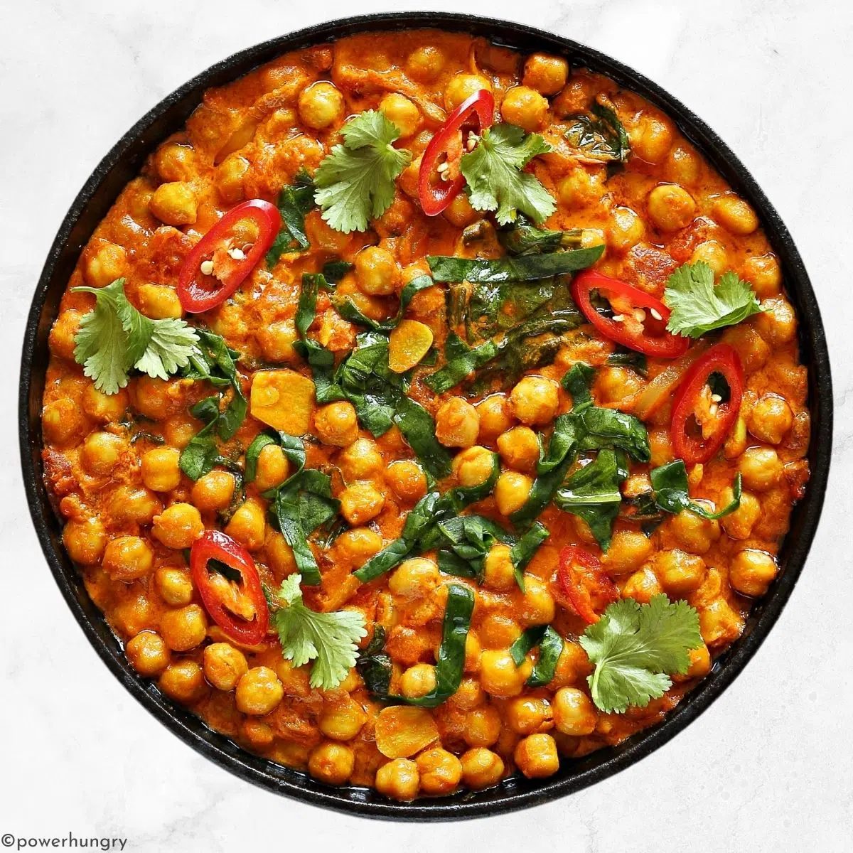 fast chickpea spinach curry in a dark brown bowl