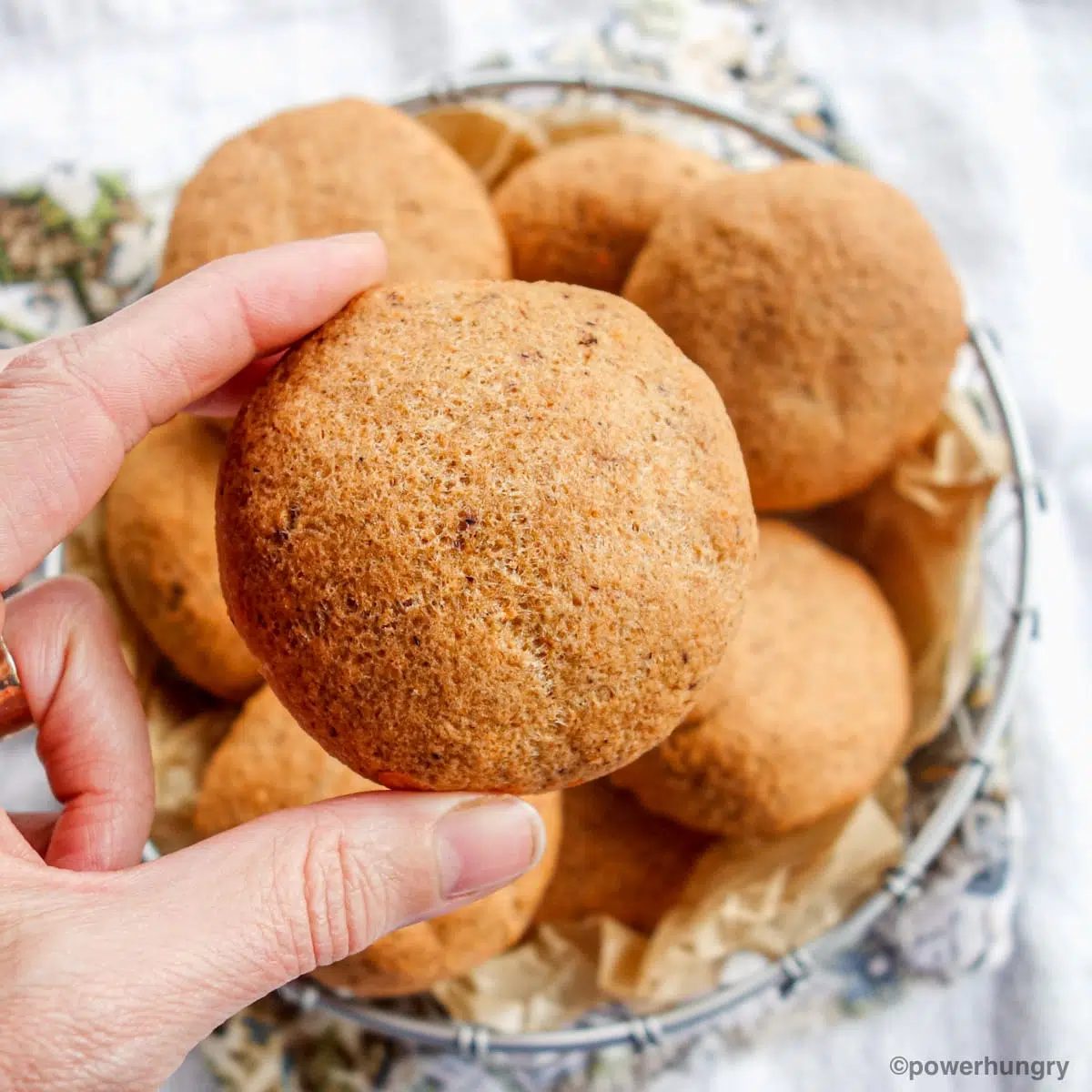 a single lentil bread rolll, held by a woman's hand