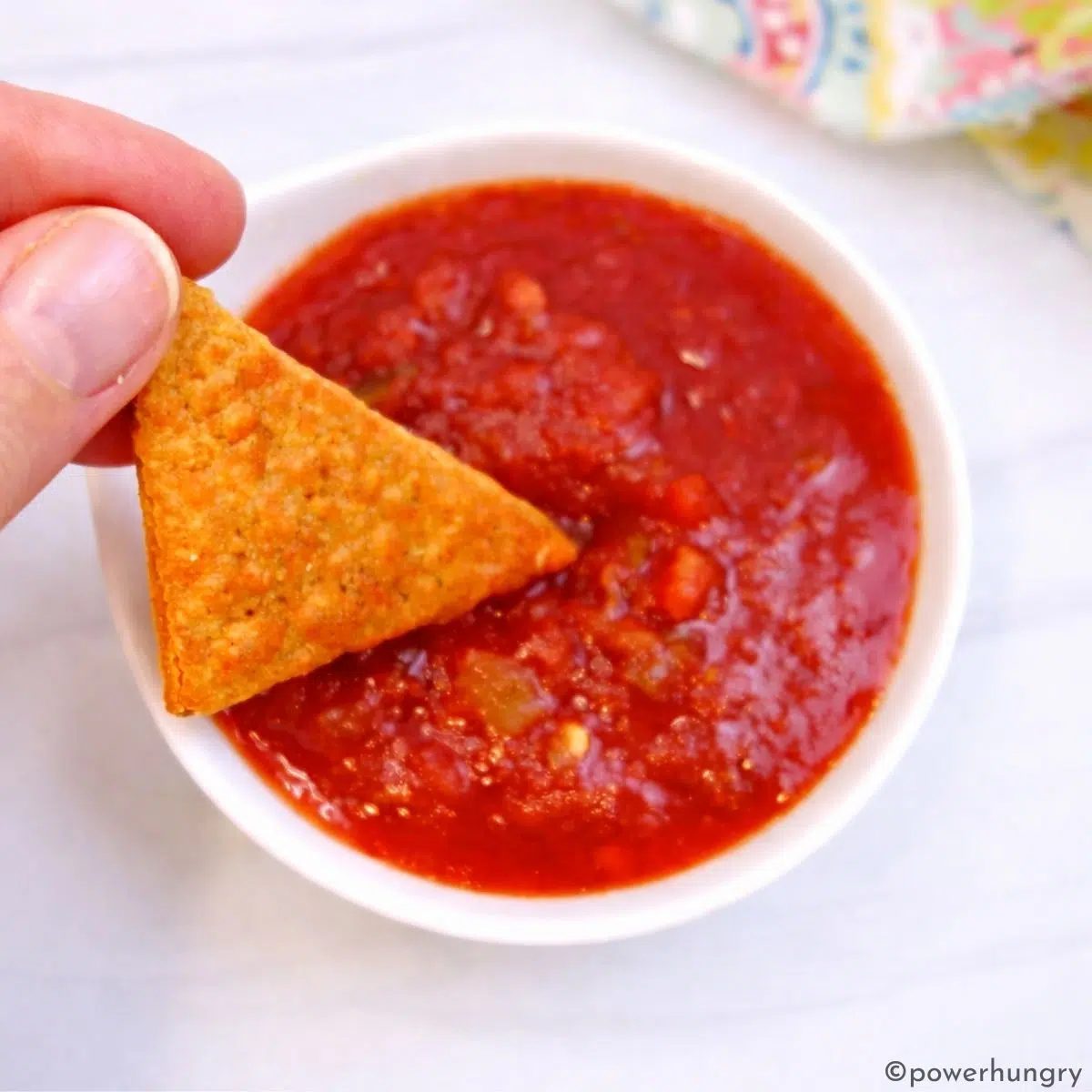 vegan lentil nacho cheese lentil chip dipped into a bowl of salsa