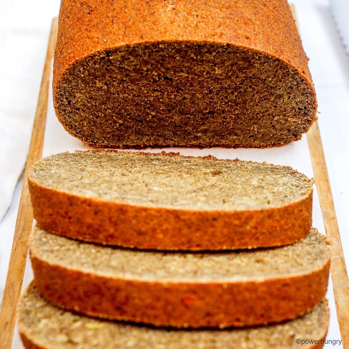 sliced loaf of pumpkin lentil bread on a cutting board