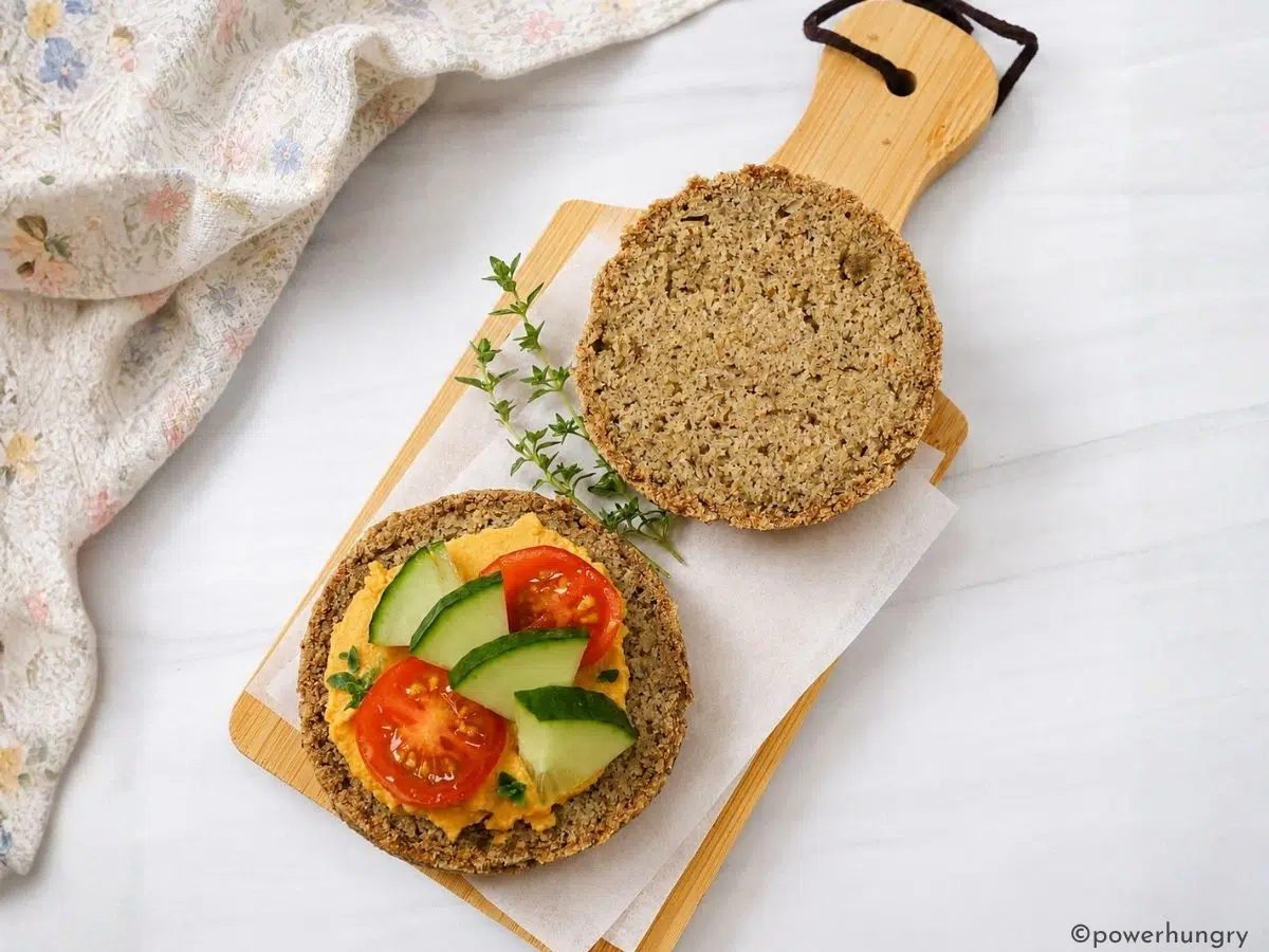 pumpkin seed bread rolls split and spread with hummus and vegetables