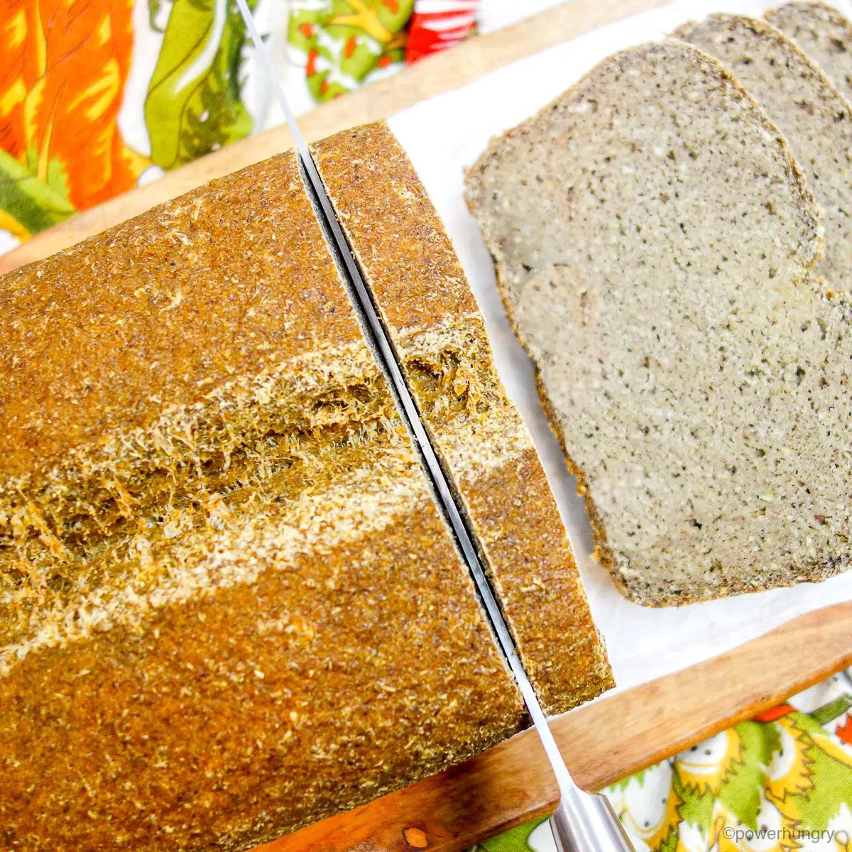 loaf of tofu lentil bread getting sliced on cutting board