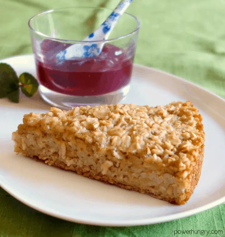 close-up of a piece of Irish oat scone bread on a white plate with a small jar of jam