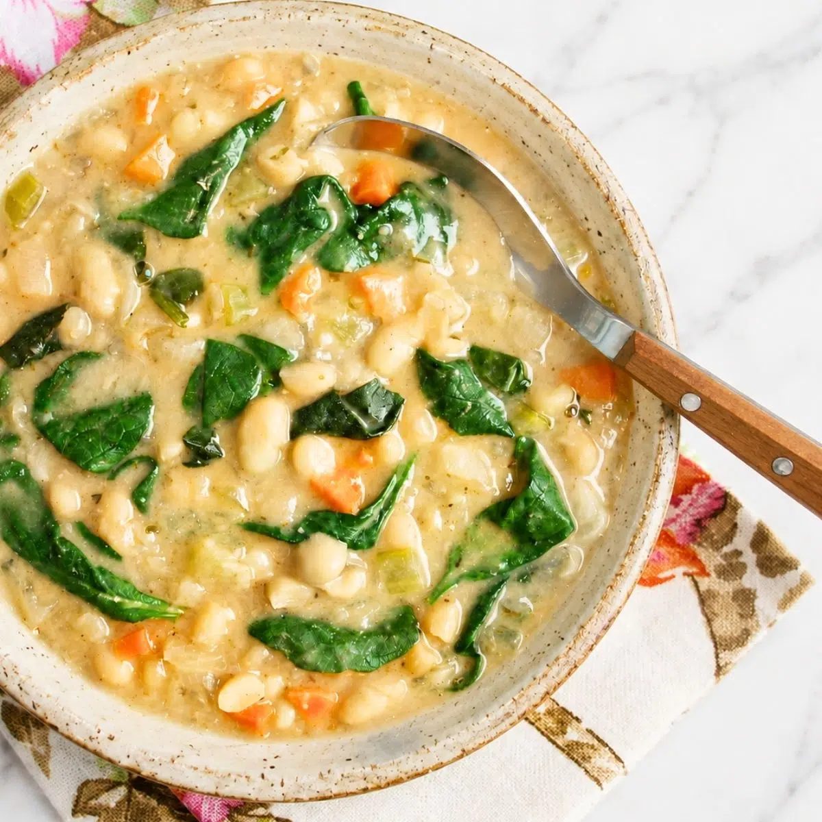 overhead shot of high protein white bean soup in a stoneware bowl