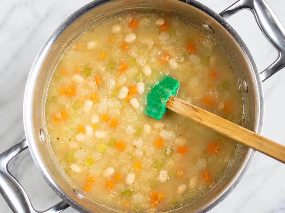 saucepan filled with high protein Italian white bean soup, simmering