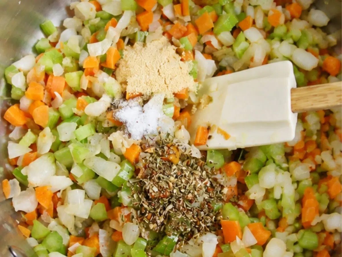 seasonings getting added to pot of softened vegetables for high protein vegetarian soup