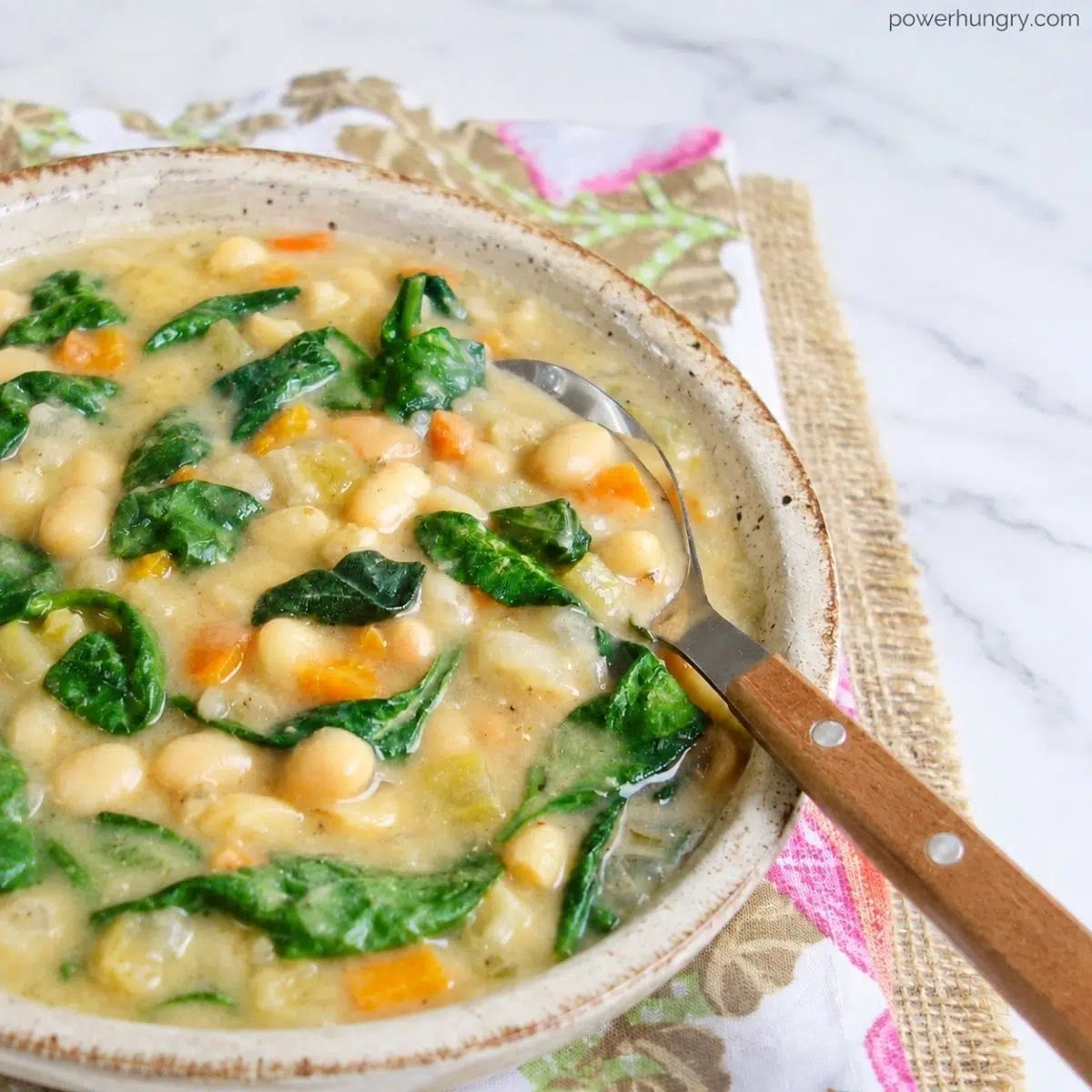 close-up of Italian white bean soup with spinach in a stoneware bowl