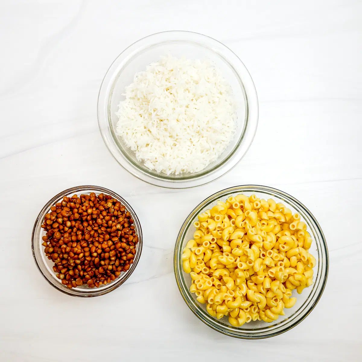 macaroni lentils and rice in glass bowls