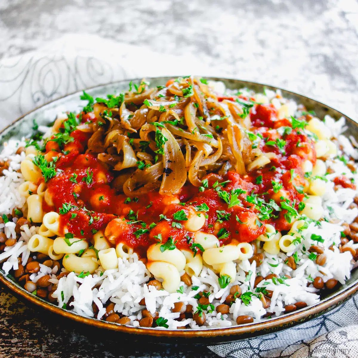 Koshari in a green ceramic dish