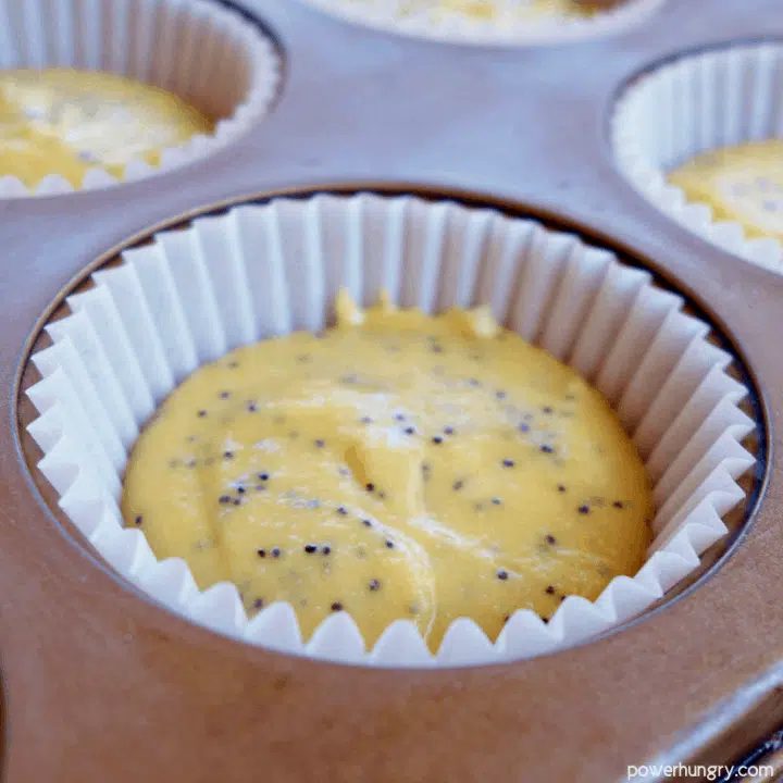 close up of a muffin cup filled with lemon poppy seed muffin batter