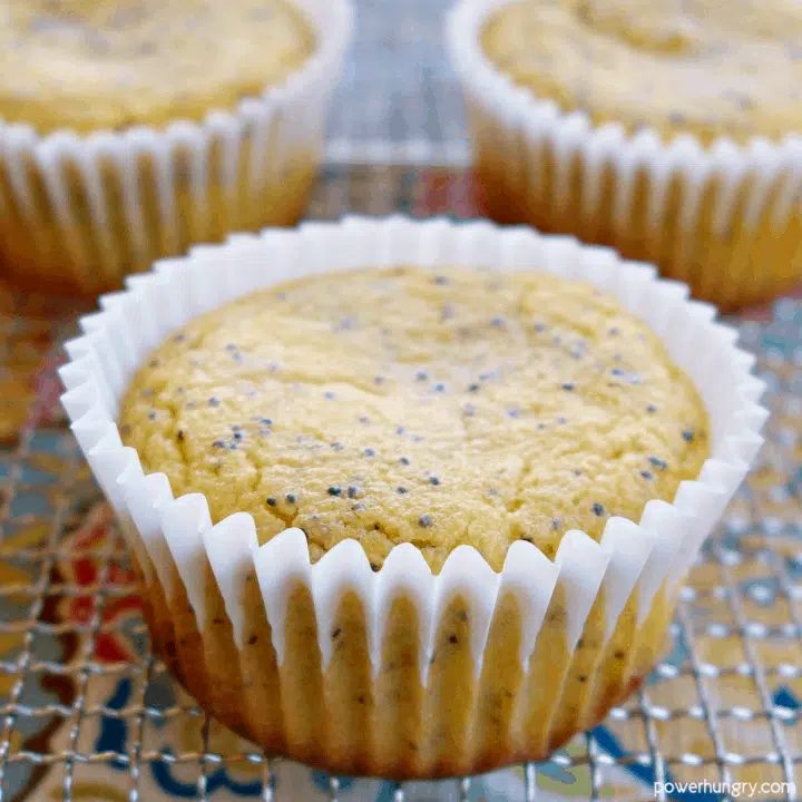 a vegan lemon poppy seed muffin on a wire cooling rack