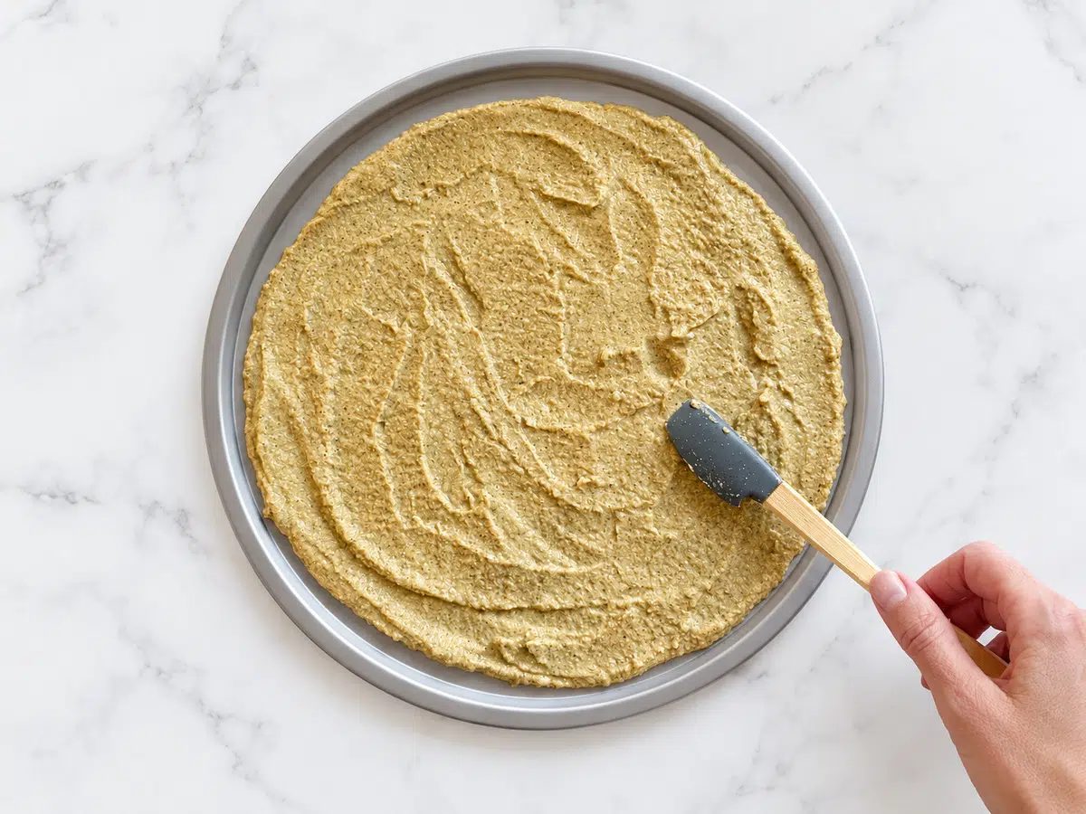 spreading the 2-ingredient pizza crust batter on the pizza pan