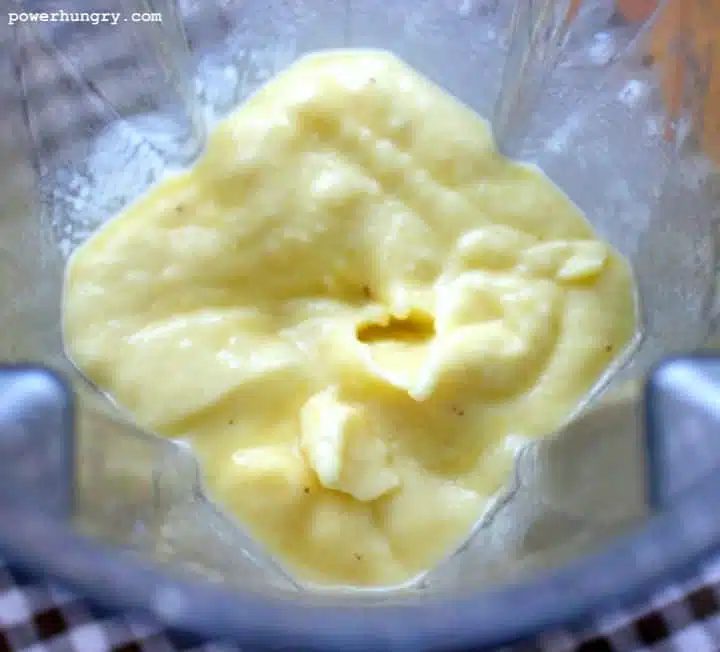 overhead shot of blender filled with banana mango coconut ice cram
