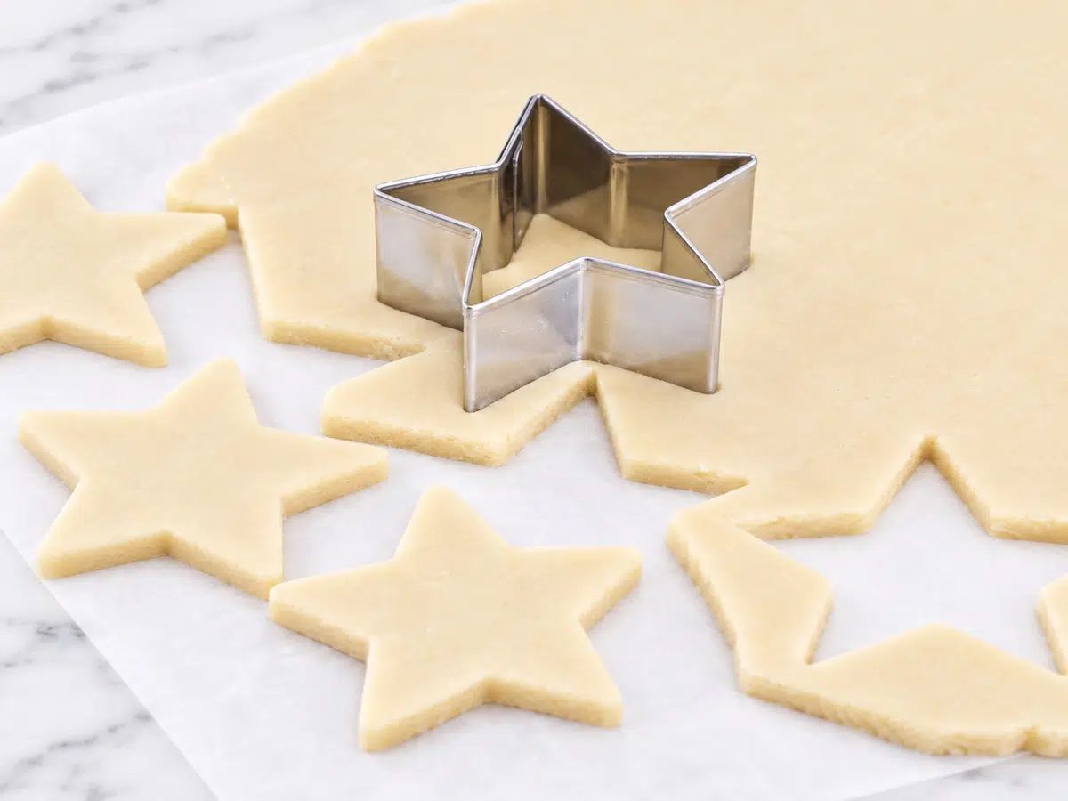 cookie cutter cutting out shapes from dough for maple almond flour cut out cookies