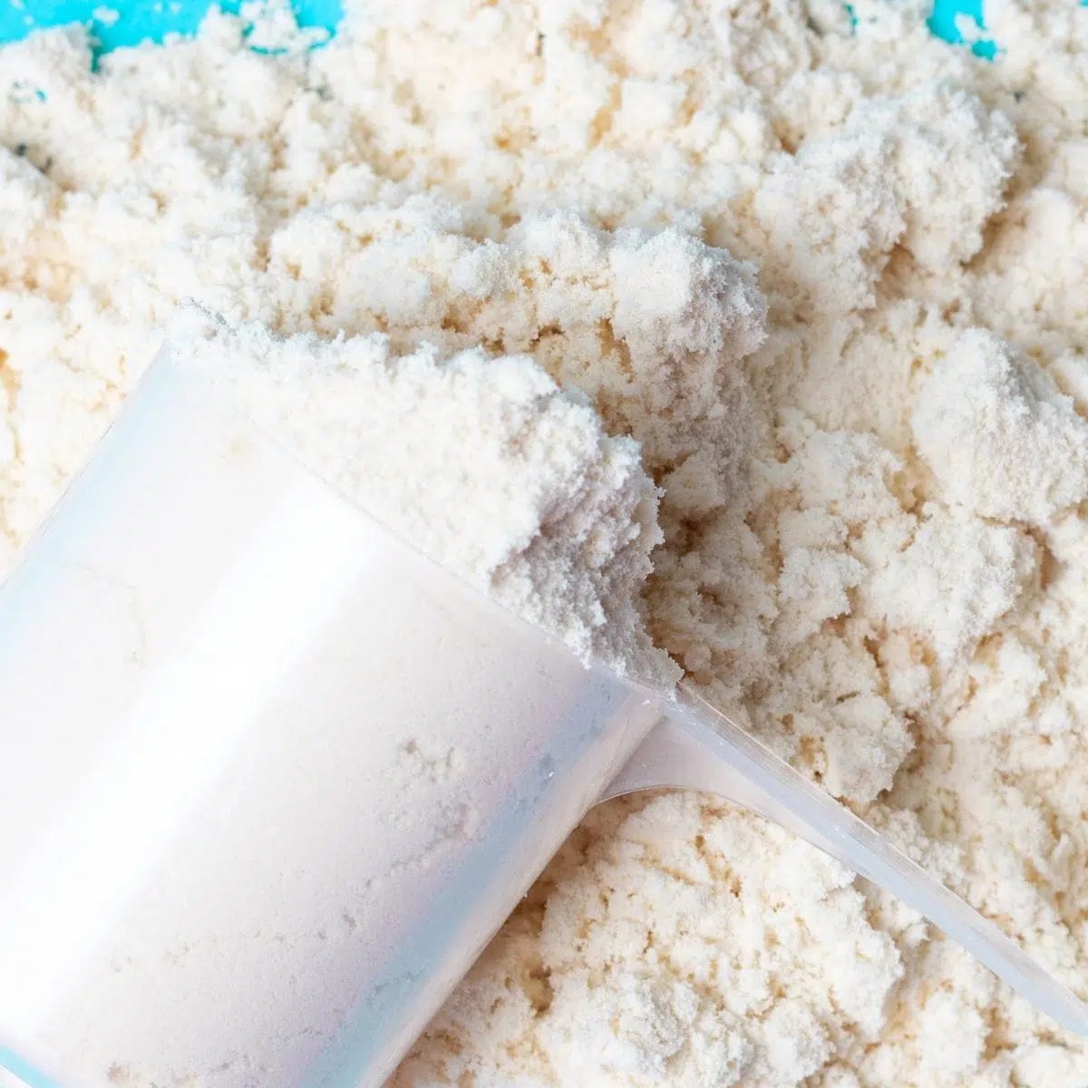 an overflowing scoop of vegan vanilla protein powder