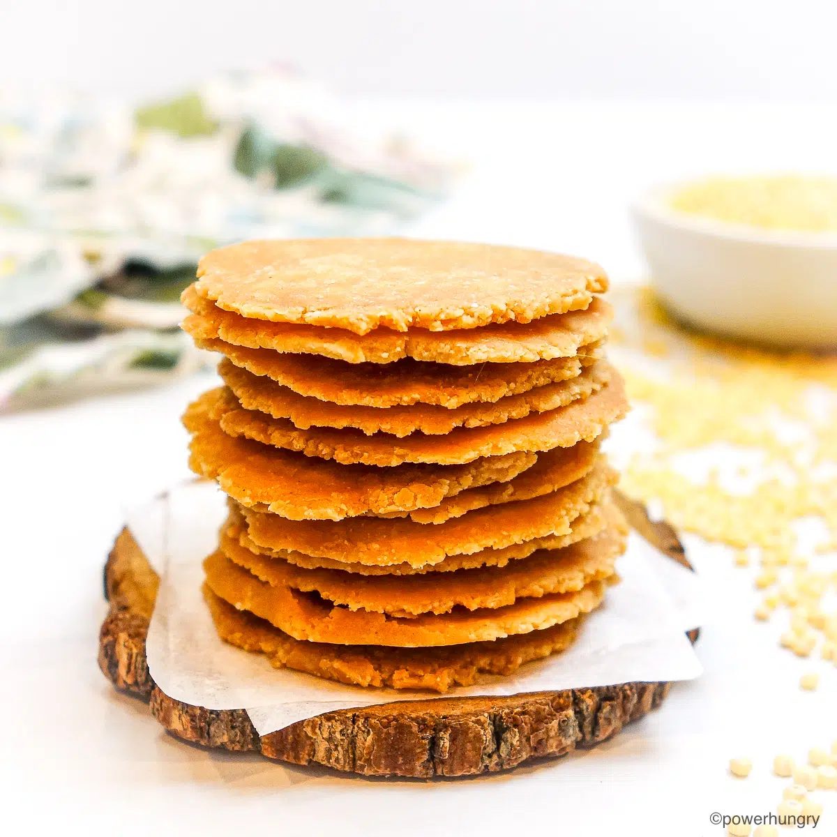 a stack of straightforward no-roll millet crackers on a piece of parchment paper