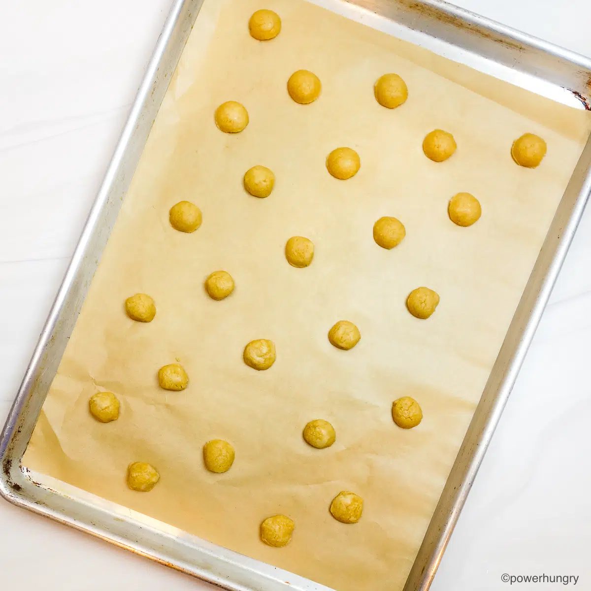 millet cracker dough portions on a parchment paper lined baking sheet