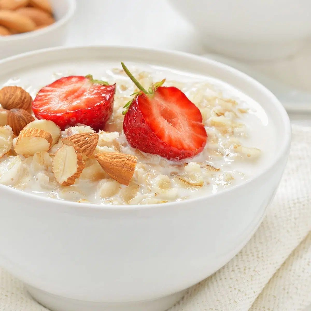 millet porridge in a white bowl topped with strawberries and almonds