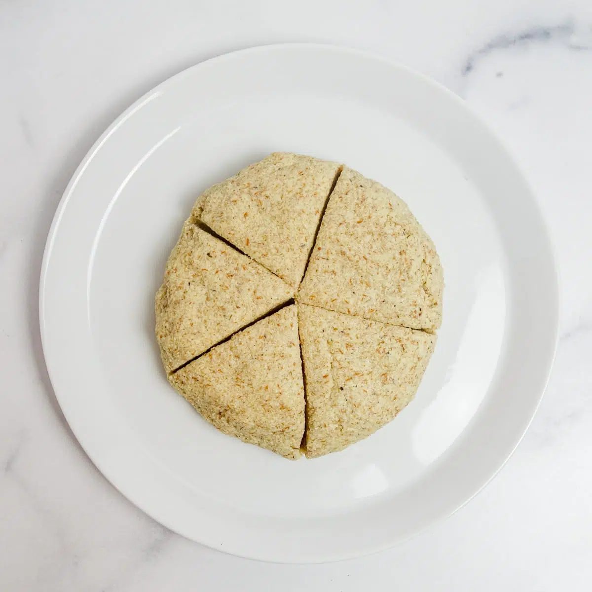 tortilla dough on a white plate, cut into 5 wedges