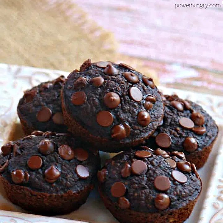 vegan chocolate oat muffins piled on a small white square plate
