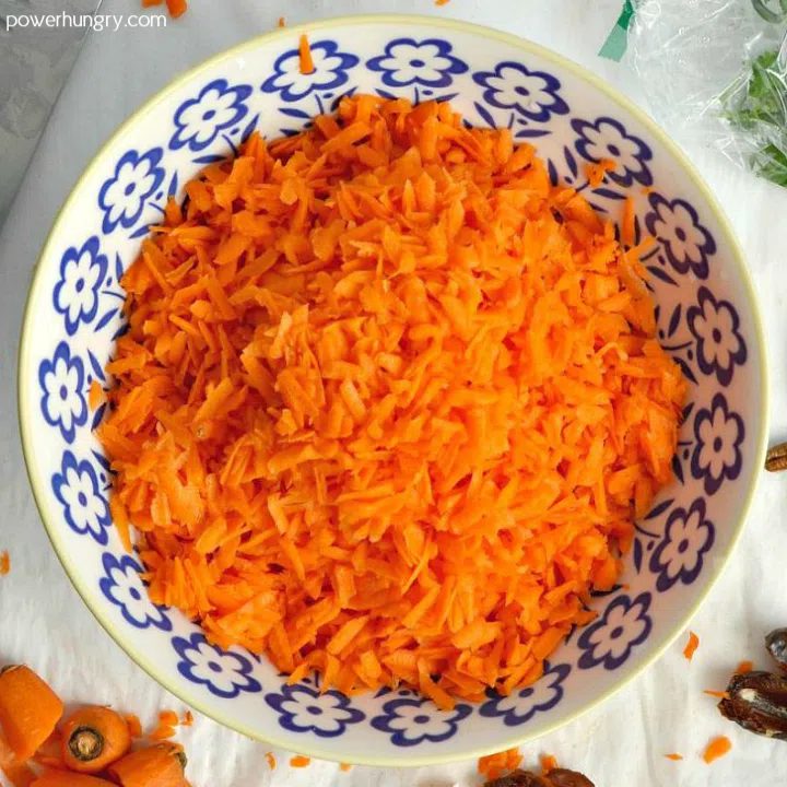 overhead shot of a blue and white bowl of grated carrots