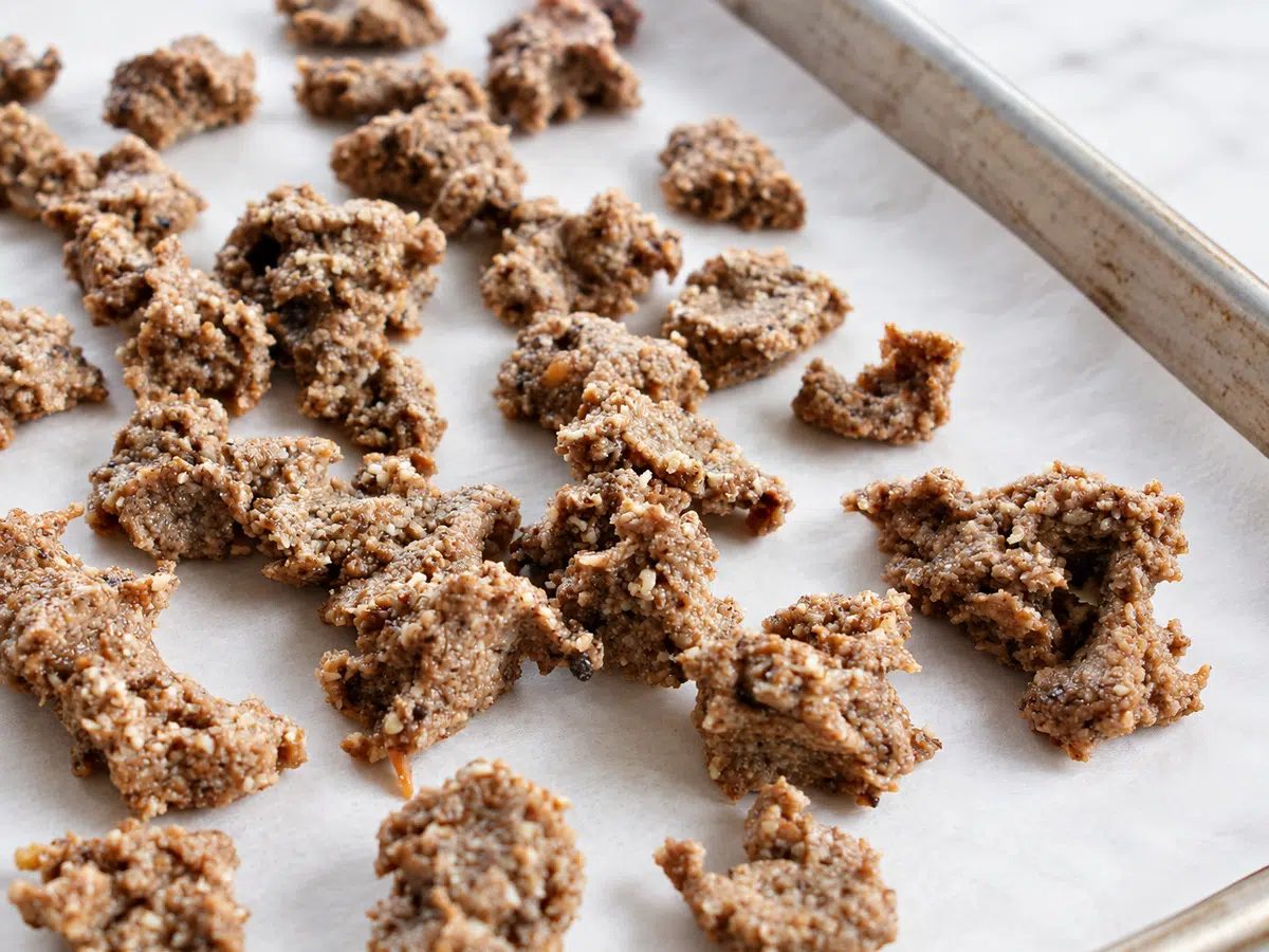 raw almond meat crumbles on a baking sheet