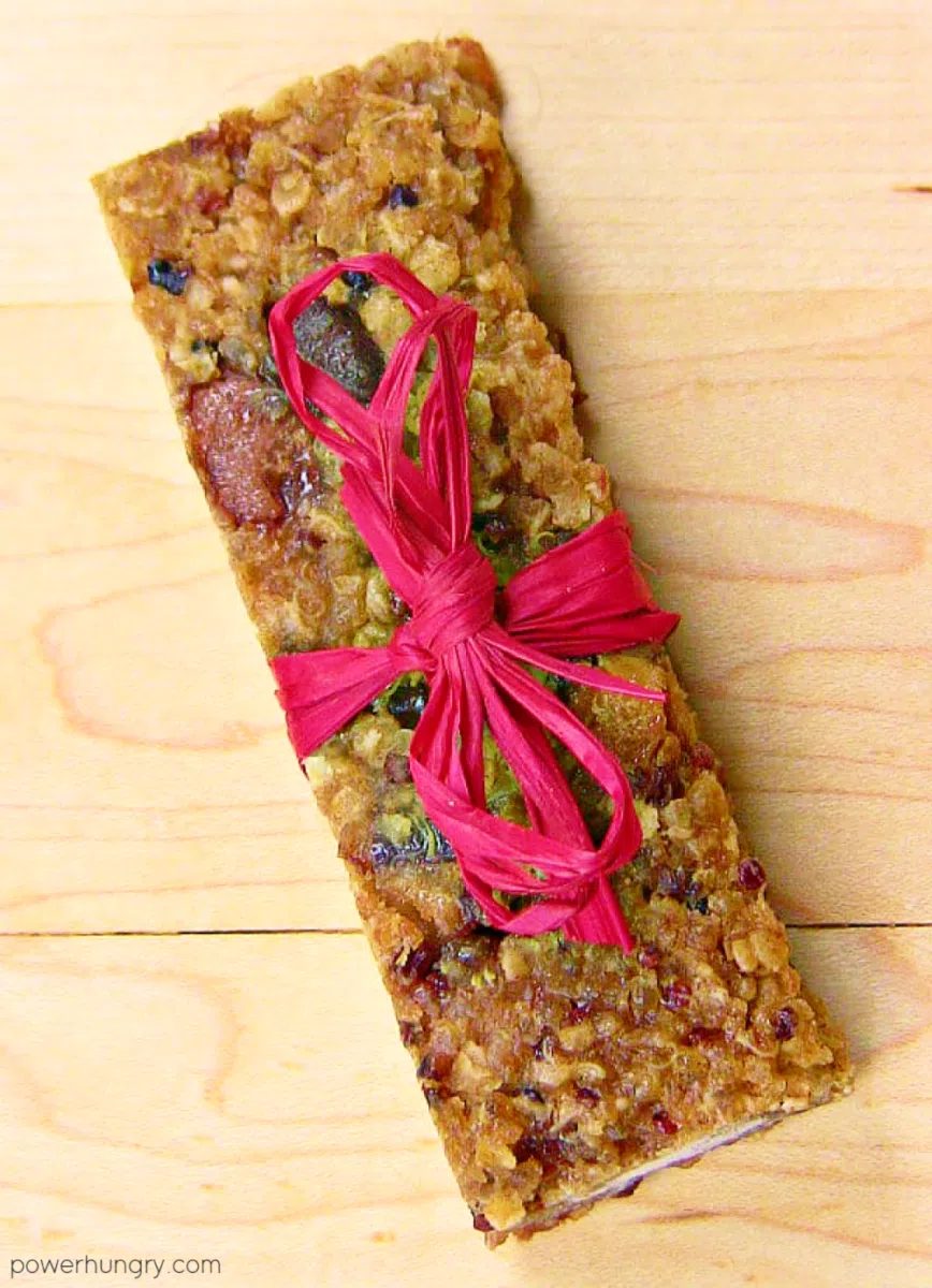 a quinoa protein bar on a pale wood cutting board