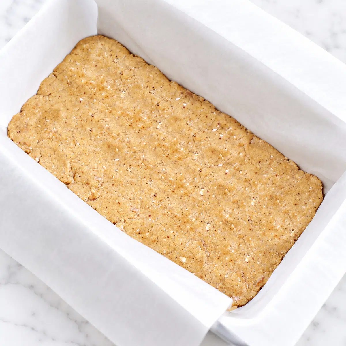no-bake tahini bars pressed into a loaf pan