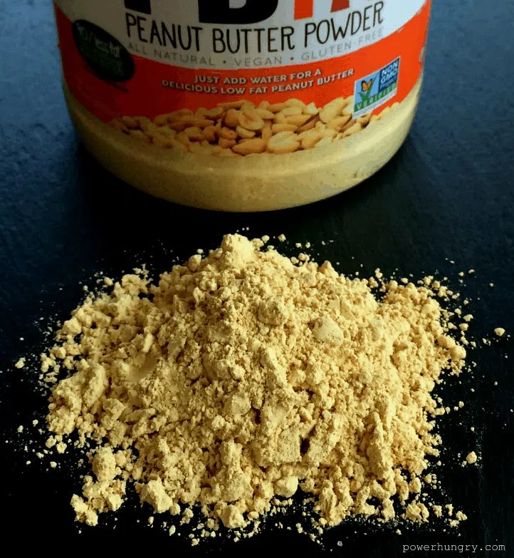 peanut butter powder on a piece of slate with the jar of peanut butter powder in the background