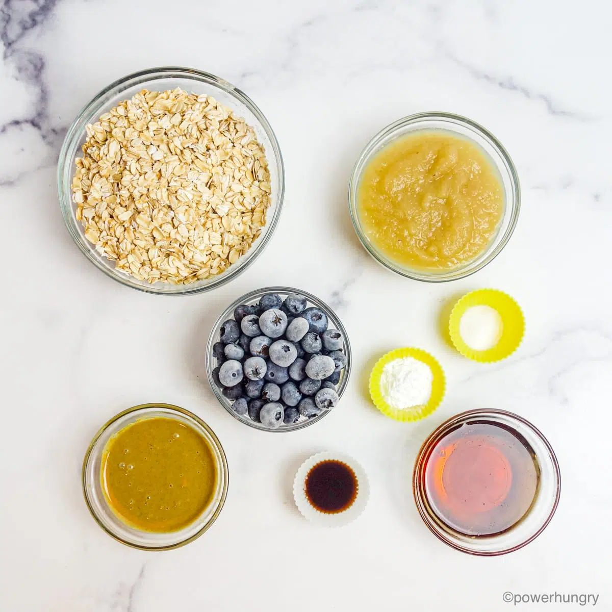 ingredients for oil-free vegan oat blueberry muffins, all in clear glass bowls