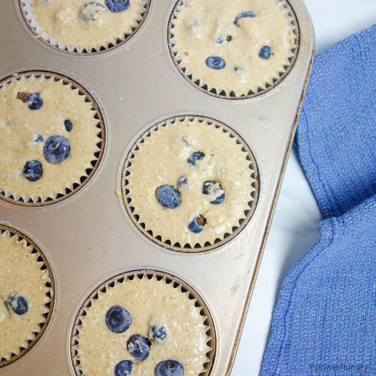 unbaked blueberry oat muffin batter in muffin cups