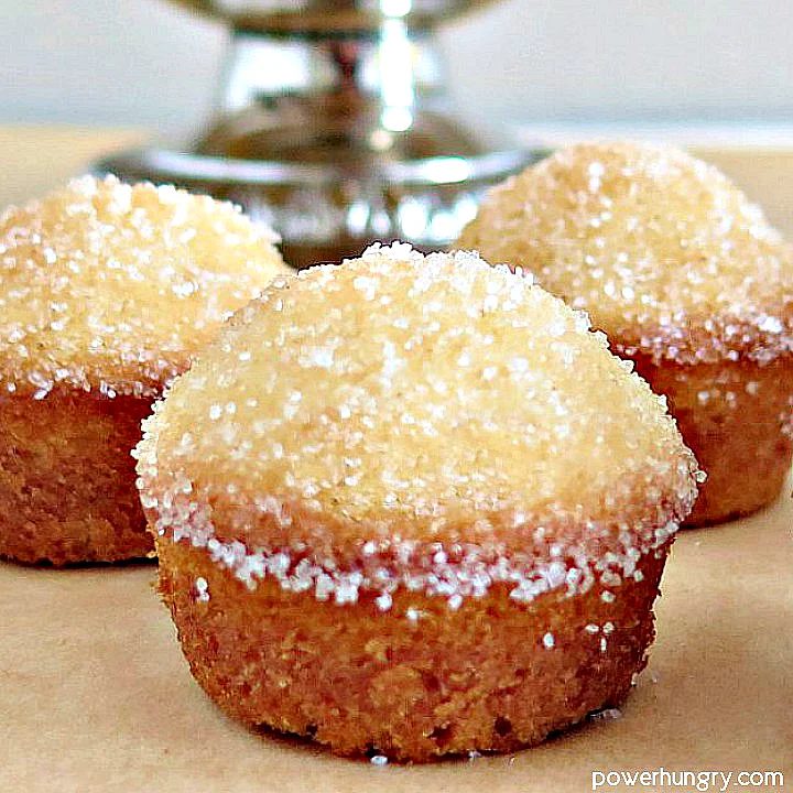 three oat almond muffins on a piece of parchment paper