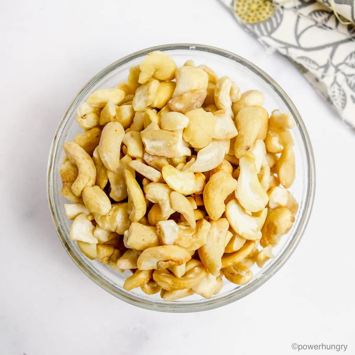 a glass bowl filled with raw cashew pieces