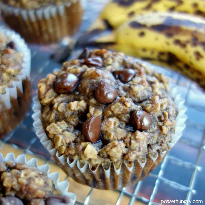 Peanut Butter Banana Baked Oatmeal Cups on a wire cooling rack with bananas in background