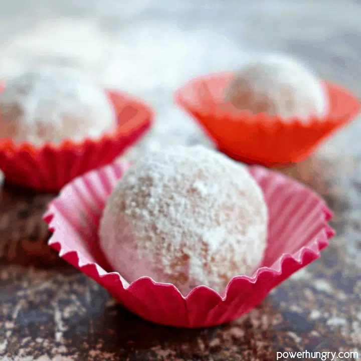 close up of protein balls, in red paper cups, made from peanut butter powder and coconut flour
