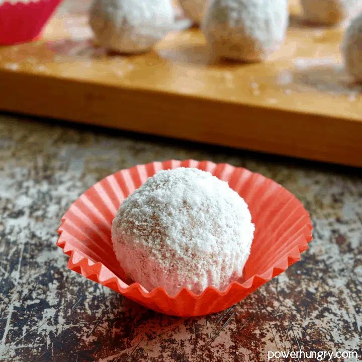 close up of peanut butter coconut flour protein ball in a red paper mini muffin liner