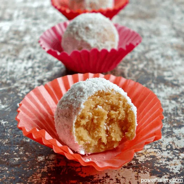 peanut butter powder coconut flour protein balls, with the one in front bittern into to reveal interior
