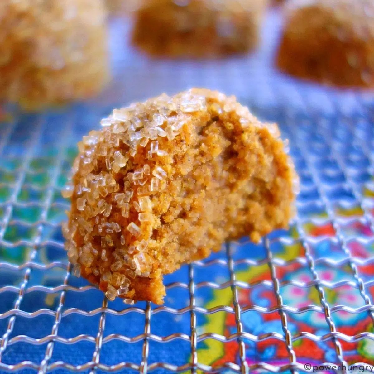 a single pumpkin vegan cookie with a bite taken out of it, showing the interior