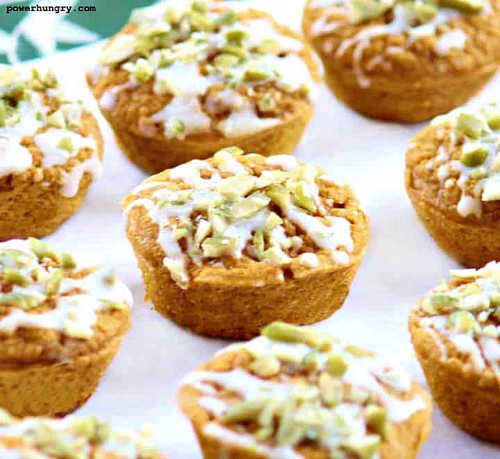 vegan pumpkin latte muffins topped with a drizzle of white chocolate and chopped pepitas